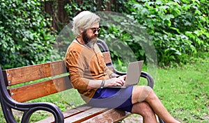 Bearded man sit on bench with laptop. online distant education. hipster inspired to work in park. agile business. mature