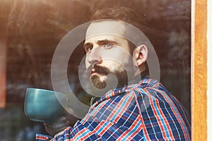 Bearded man sitting with cup of coffee