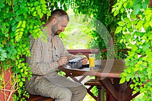 Bearded man sitting at vintage design wooden arbor