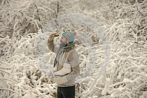 Bearded man with skates in snowy forest.