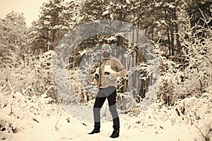 Bearded man with skates in snowy forest.