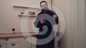 Bearded man with smartphone dancing