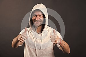 Bearded man smile with thumbs up. Happy man with beard wear hood. Fashion model in hoodie tshirt. Active lifestyle and