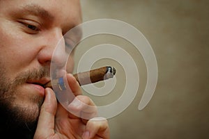 Bearded man smokes cigar