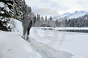 A bearded man snowshoeing around Island Lake in Fernie, British Columbia, Canada.
