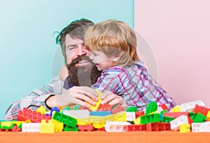 Bearded man and son play together. Surefire ways to bond with your son. Father son game. Dad and kid build plastic