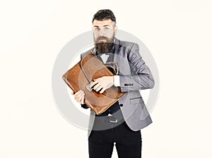 Bearded man standing with vintage brown suitcase
