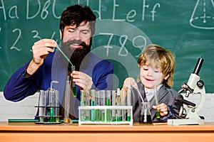 bearded man teacher with little boy. biotechnoloy research concept. father and son at school. Back to school. Explaining