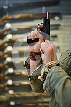 Bearded man twitches the pistol bolt in gun store