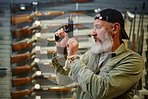 Bearded man twitches the pistol bolt in gun store