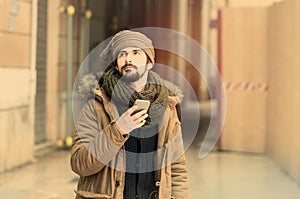 Bearded man using smart phone in the city instagram tone