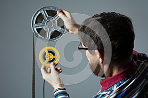 Bearded man watch two film reel 16mm