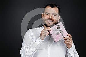 Bearded man in white shirt holding gift box