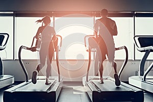 Bearded Man and Young Woman on Treadmills in Gym.