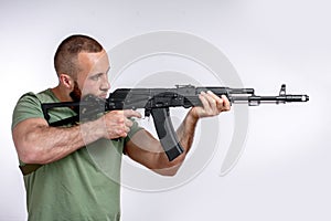 Man in casual clothing with sniper rifle aiming  on white photo