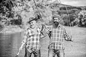 Bearded men catching fish. Mature man with friend fishing. Summer vacation. Happy cheerful people. Family time