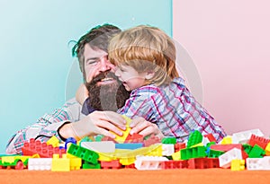 Bearded man and son play together. Surefire ways to bond with your son. Father son game. Dad and kid build plastic photo