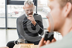 bearded middle aged man smelling puer