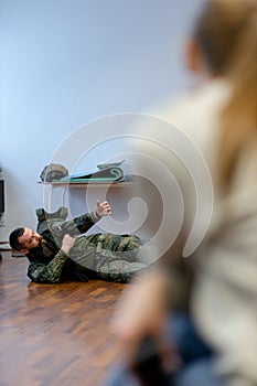 A bearded military medic demonstrates to civilians medical tourniquet