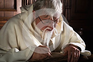 Bearded monk writing with quill