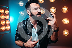 Bearded performer with microphone sing a song