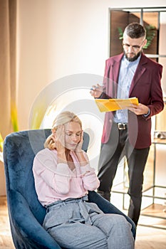 Bearded psychoanalyst wearing glasses standing near patient