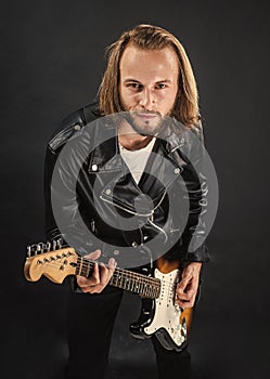 bearded rock musician playing electric guitar in leather jacket, electric bass