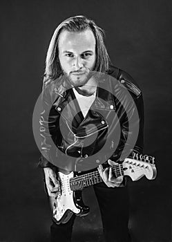 bearded rock musician playing electric guitar in leather jacket, electric bass