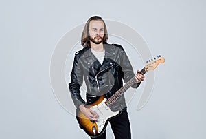 bearded rocker in leather jacket. man long hair play electric guitar. rock music style.