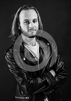 bearded rocker in leather jacket. man with long hair. rock style fashion. stylish brutal man hipster.