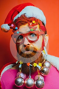 Bearded Santa Claus - close up portrait. Beard with Christmas decoration. Funny santa Wish you merry christmas.