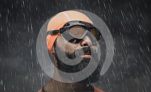 Bearded scuba swimmer under rain drops.