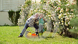 Bearded senior gardener in an urban garden. Gardener cutting flowers in his garden. Gardening - Grandfather gardener in