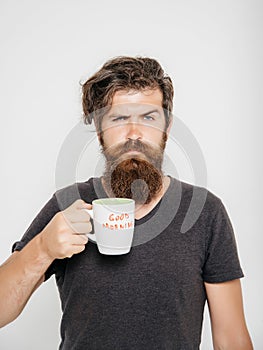 Bearded serious man with cup of coffee or tea