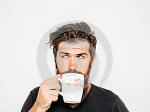 Bearded serious man with cup of coffee or tea