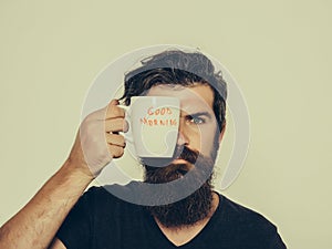 Bearded serious man with cup of coffee or tea