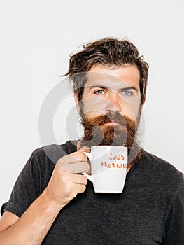 Bearded serious man with cup of coffee or tea