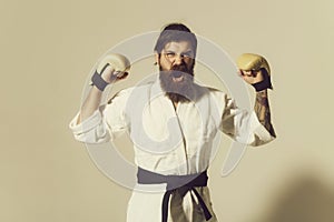 Bearded shouting happy karate man in kimono and boxing gloves
