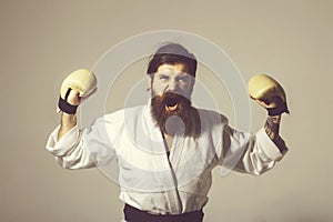 Bearded shouting happy karate man in kimono and boxing gloves