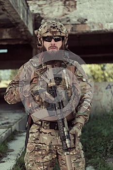 A bearded soldier in uniform of special forces in a dangerous military action in a dangerous enemy area. Selective focus
