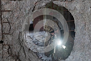 A bearded soldier in uniform of special forces in a dangerous military action in a dangerous enemy area. Selective focus