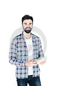 Bearded student holding copybooks and looking at camera isolated