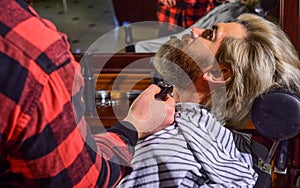 Bearded and stylish. hipster man with beard cutting his hair in a barbershop. Professional hairdressing work. Lifestyle