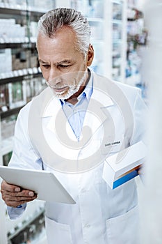 Bearded sunburnt Caucasian man in a white coat looking contented