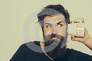 Bearded surprised man with cup of coffee or tea