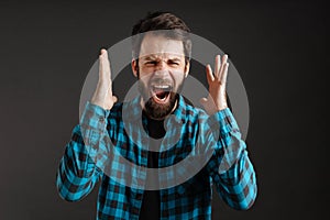 Bearded white angry man screaming at camera with hands up