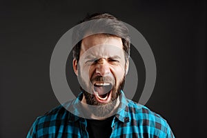 Bearded white angry man screaming and looking at camera