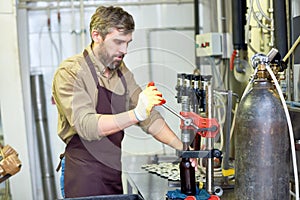 Bearded Worker Using Bottle Capper