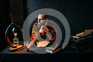 Bearded writer in glasses sitting at the table