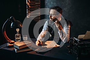 Bearded writer in glasses smoking a pipe